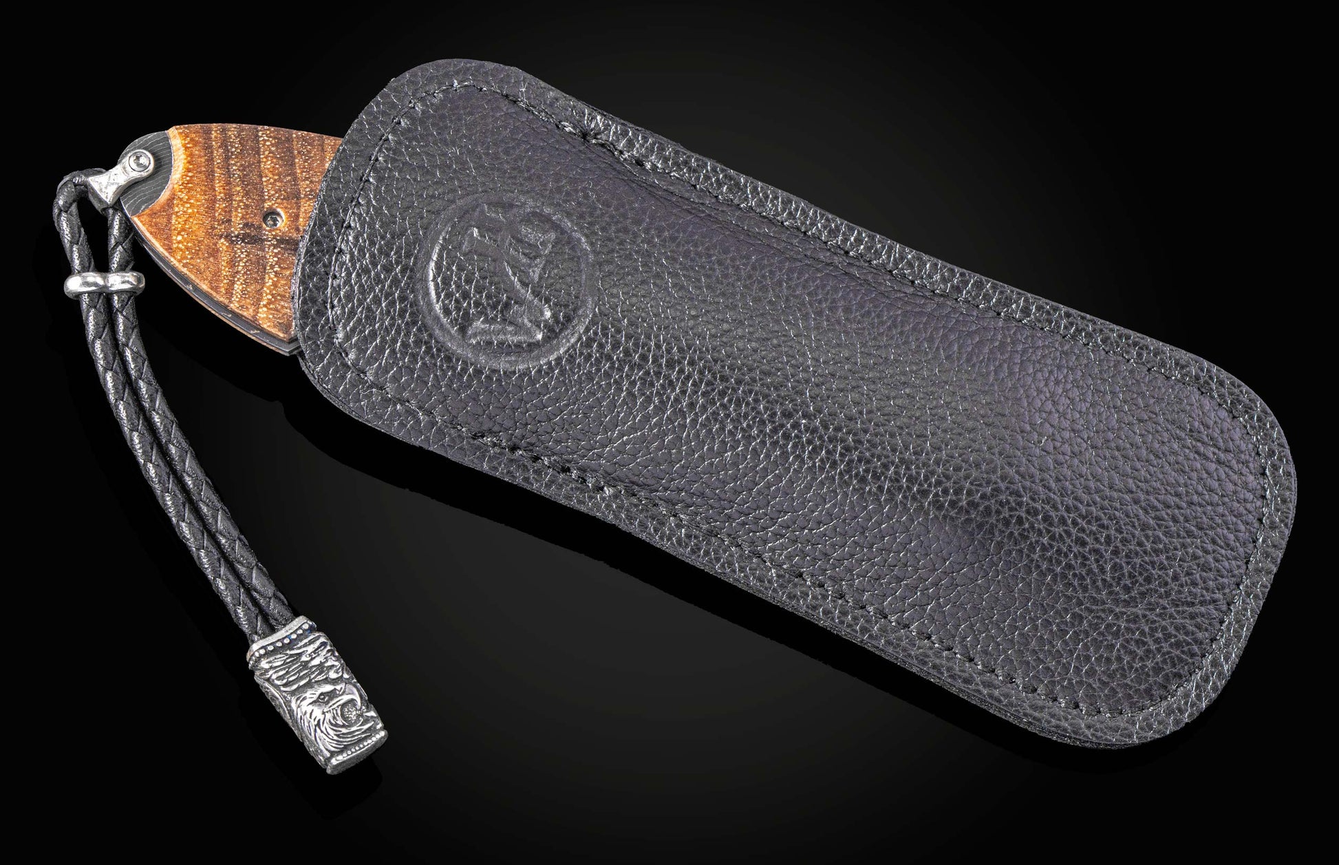 Folding knife with wooden handle and damascus blade on a black background