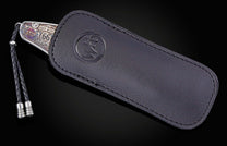Metallic knife with "Route 66" engraving, braided lanyard, and partially sheathed in black leather featuring a debossed 'WH' logo.