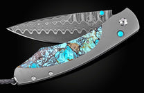 Damascus steel folding knife with turquoise inlay and wave pattern blade, by B12, featuring brushed titanium handle and gemstone accents, side view on black background