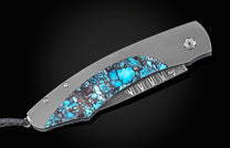 Turquoise inlay folding knife with brushed titanium frame and damascus blade, side view on black background