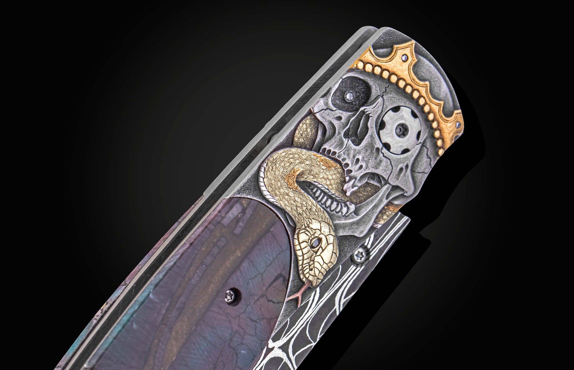 Decorative knife with skull and snake design on a dark background