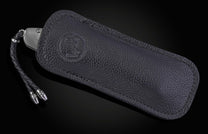 knife in black leather case on black background