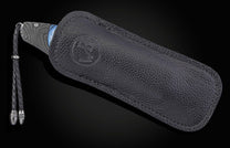 Folding knife with damascus blade and carved agate handle on a black background