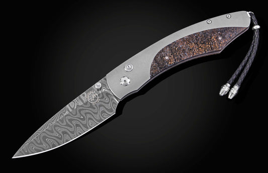 Folding knife with Damascus patterned blade and titanium handle featuring a textured fossil inlay, complete with a braided black lanyard.