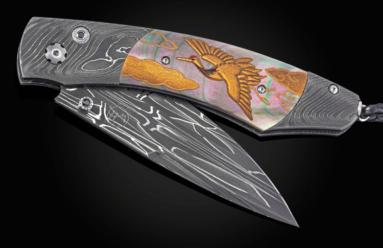 Decorative folding knife with artistic blade and embellishments on a dark background