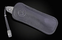 Folding knife with wooden handle and decorative blade on a black background