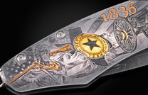 Decorative folding knife engraved with images from the Alamo on a black background