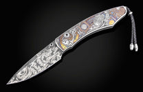 Decorative knife with intricate designs on a black background