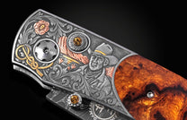 Luxury B12 Wrangler knife with intricate silver engraving, amber gemstones, and burl wood handle, side view detail