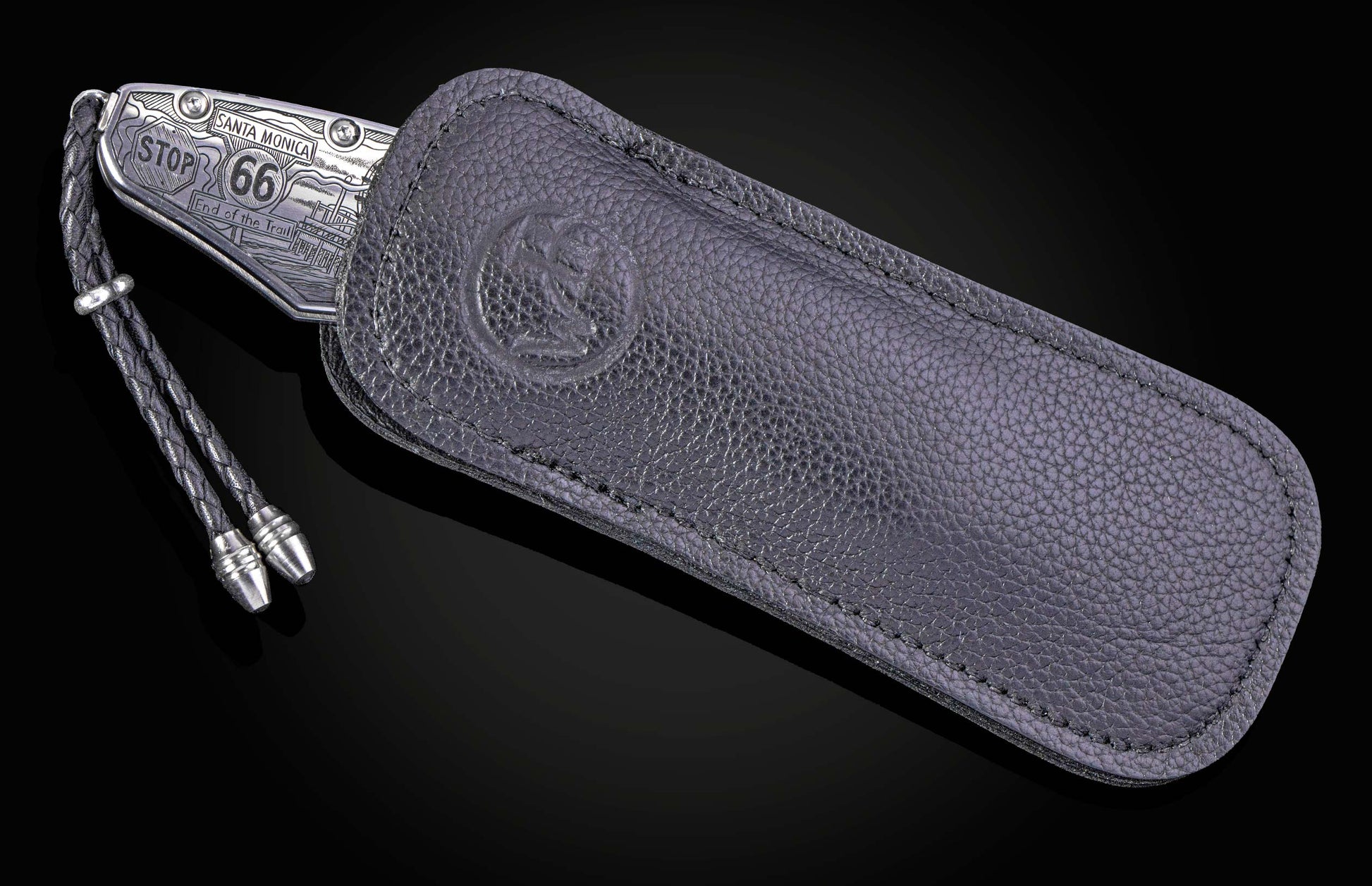 Hand engraved William Henry knife with depictions of Route 66 on a black background