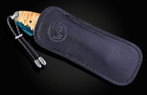 William Henry knife with a damascus steel blade and shockwood handle on a black background