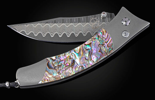 Foldable knife with abalone shell handle on a black background