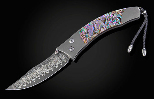 Foldable knife with abalone shell handle on a black background