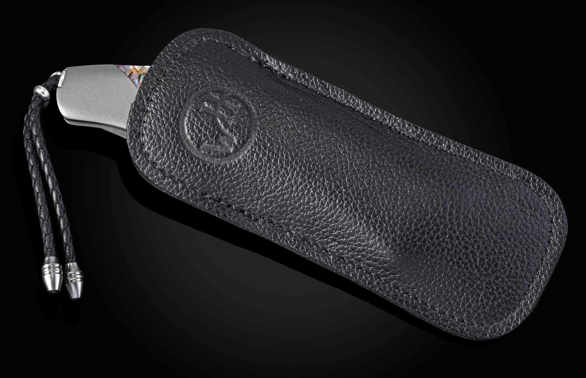 Foldable knife with abalone shell handle on a black background