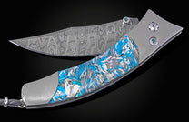 Folding knife with a blue, grey, and white fragmented urban camo handle and patterned Damascus steel blade.