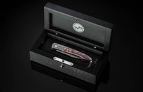 Pocket knife in a wooden display case with WH logo.