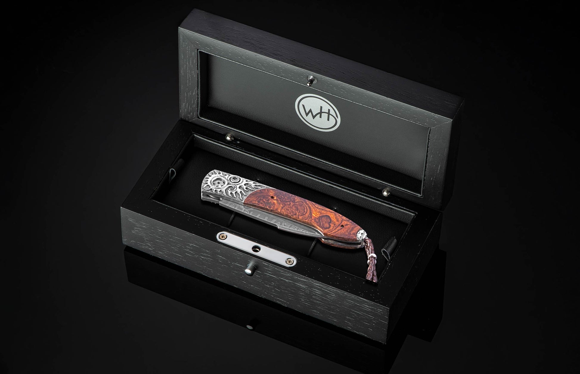 Stainless steel folding knife with wood handle and engraved bolster by B22, displayed in black presentation box with logo.