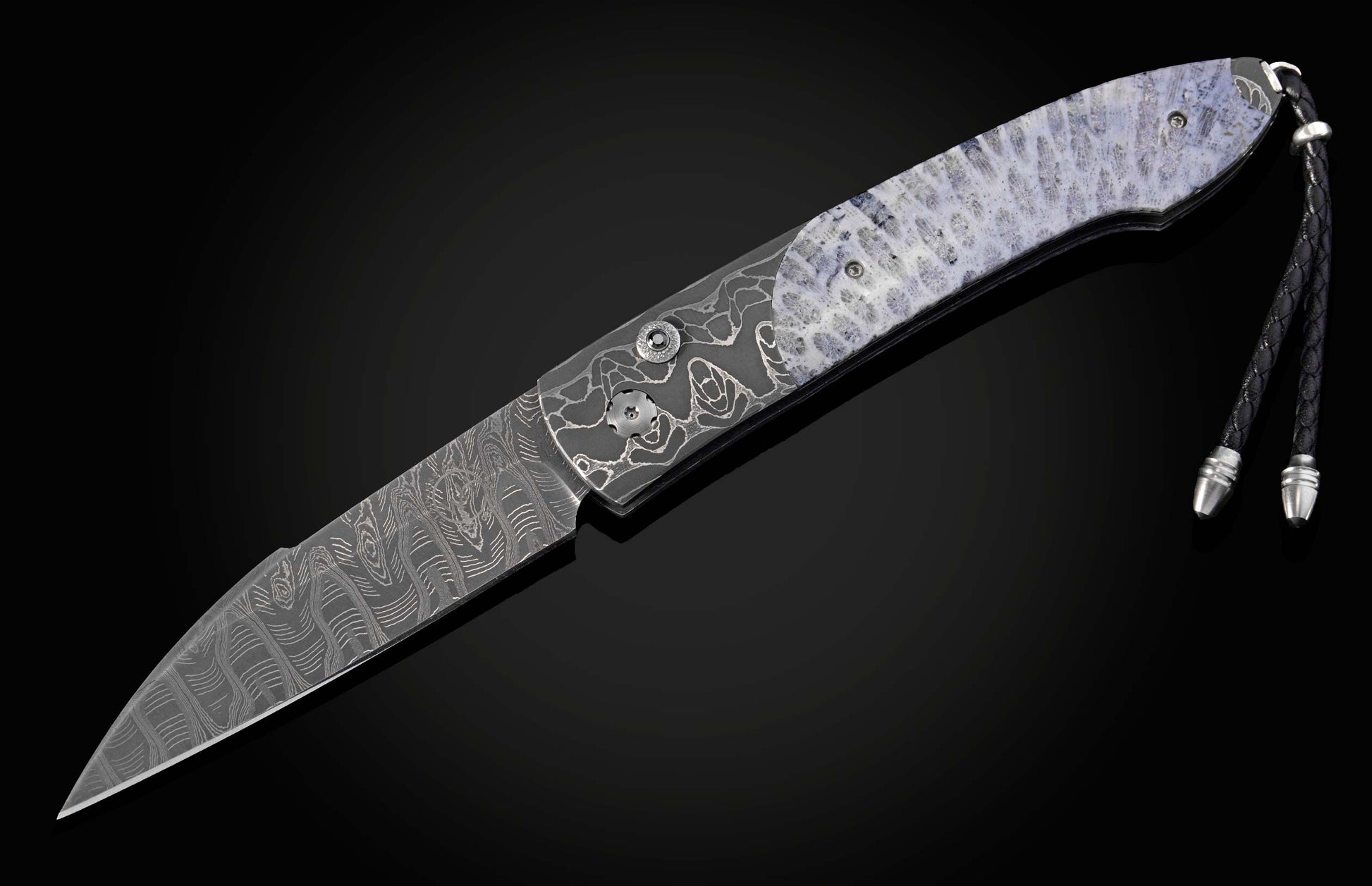 Decorative folding knife with intricate patterns on a dark background