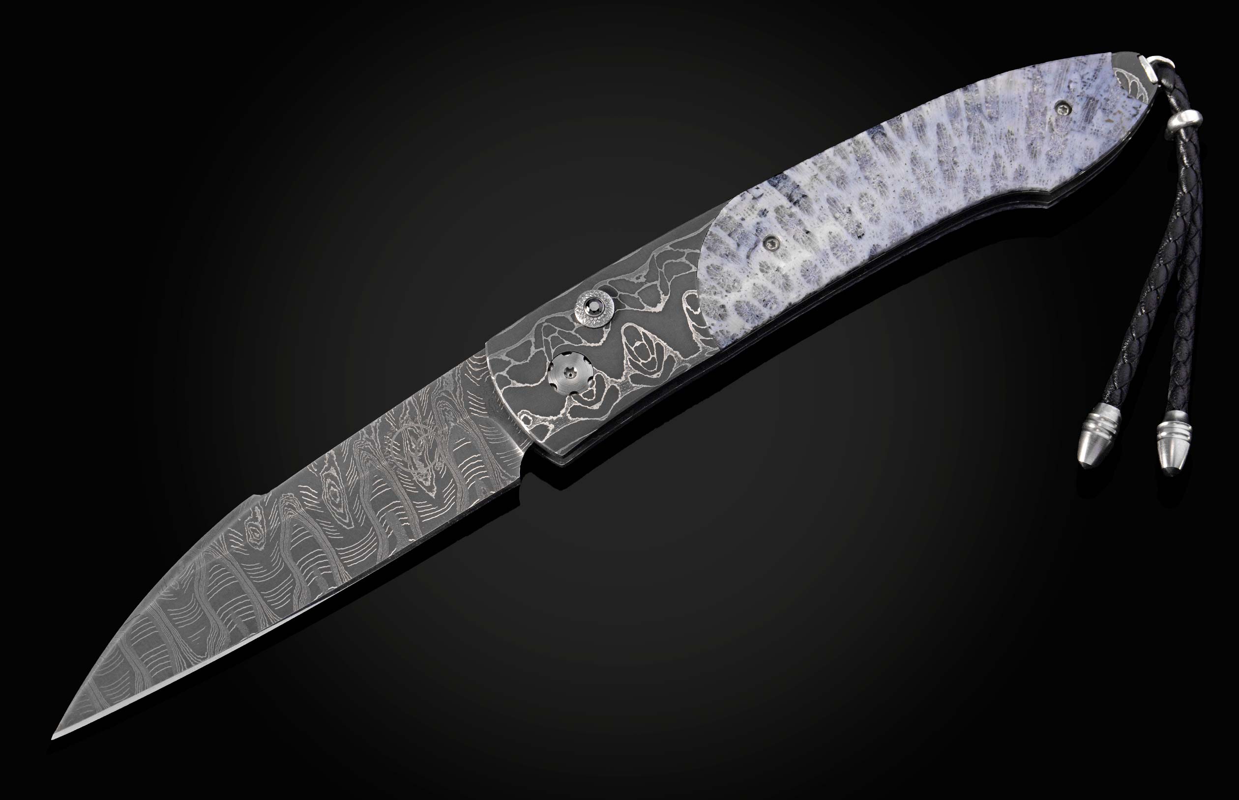 Decorative folding knife with intricate patterns on a dark background