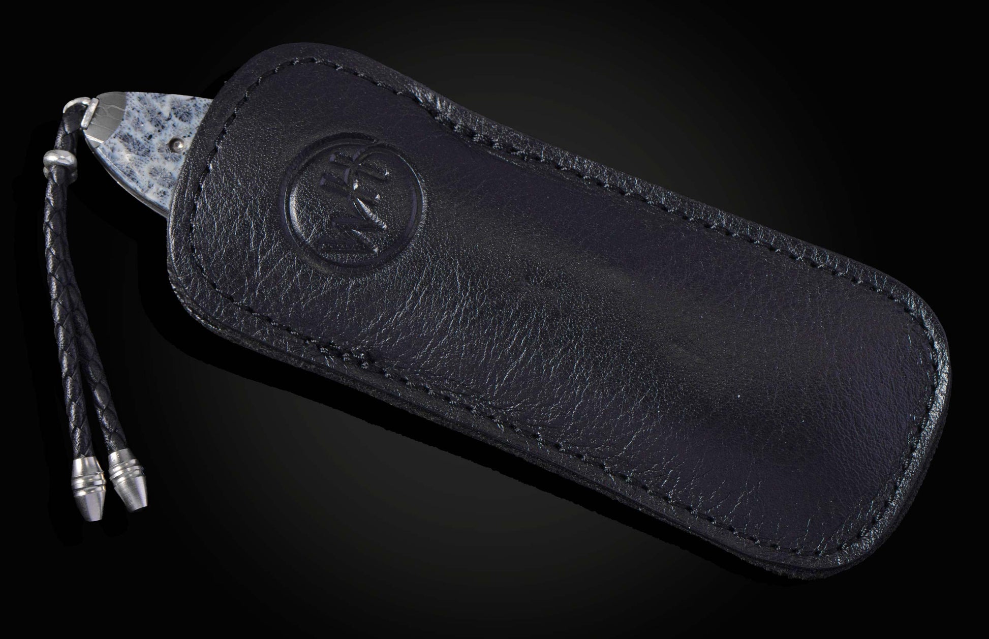 Decorative folding knife with intricate patterns on a dark background