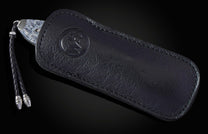 Decorative folding knife with intricate patterns on a dark background