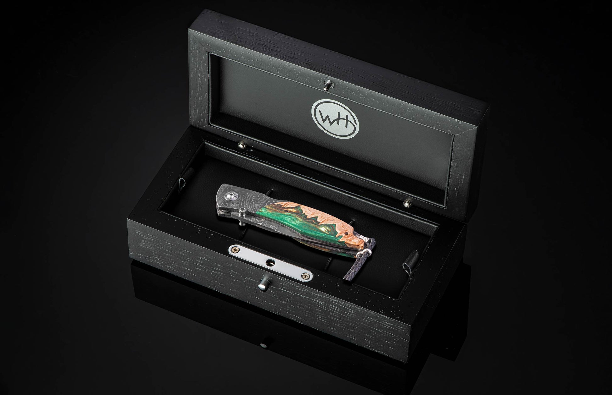 Knife in a black display box with WTH logo on a dark background