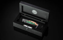 Knife in a black display box with WTH logo on a dark background
