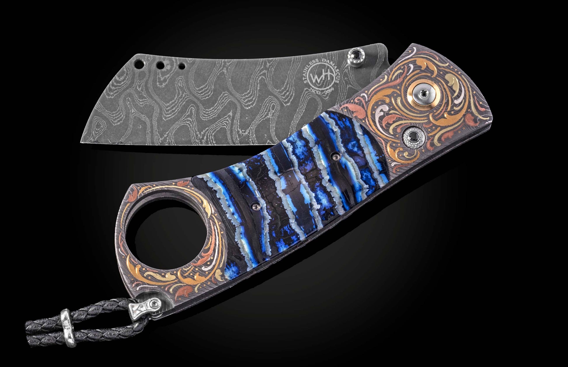 Luxury cigar cutter with damascus steel blade and blue resin inlay handle, featuring gold-toned floral engraving and braided lanyard, side view on black background
