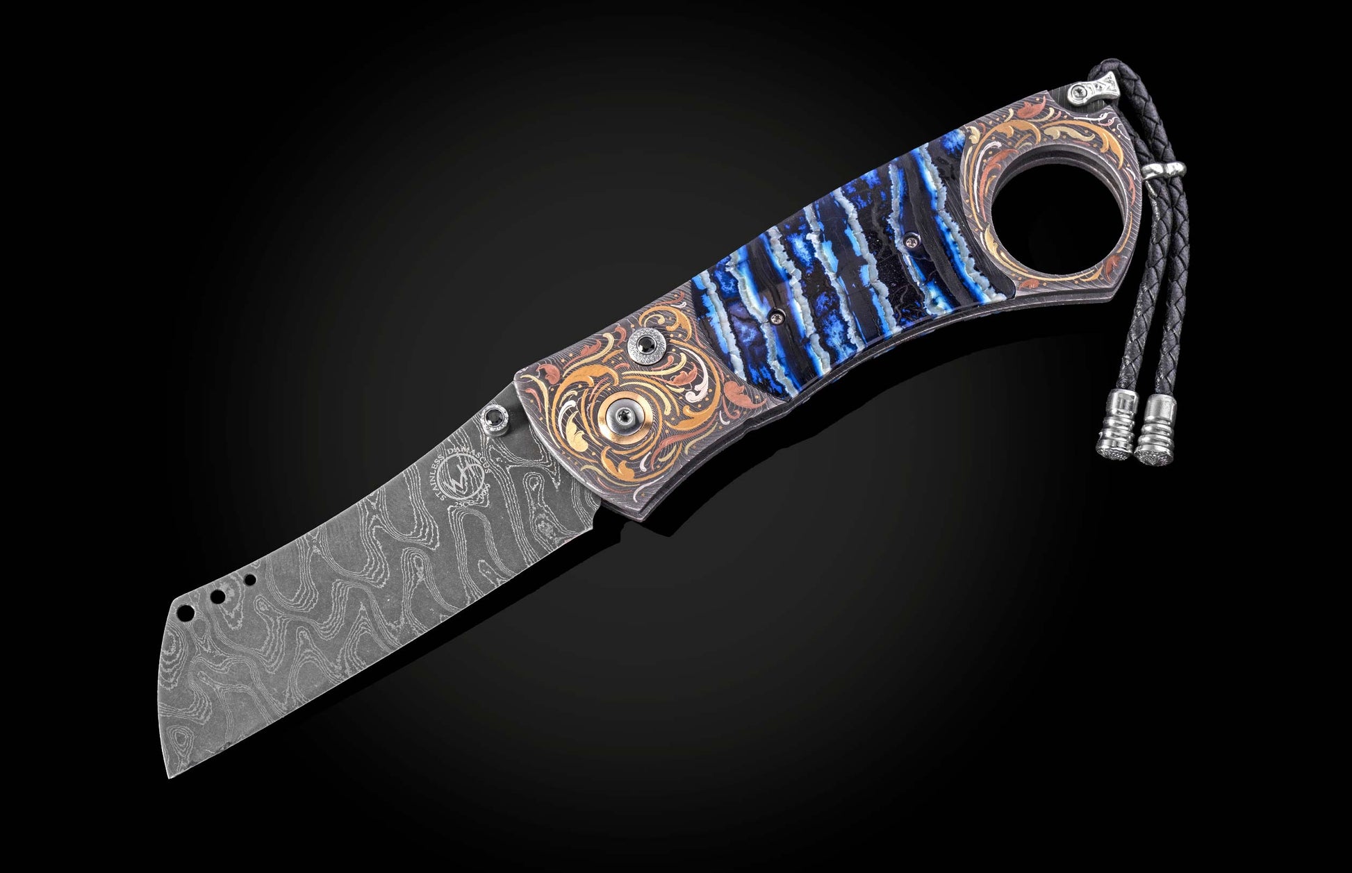 Luxury cigar cutter with damascus steel blade and blue resin handle, featuring ornate gold inlays and braided cord, side view on black background