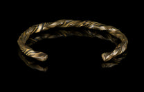 Twisted gold and black mokume-gane cuff bracelet by HC12, featuring layered metallic texture and reflective surface on dark background
