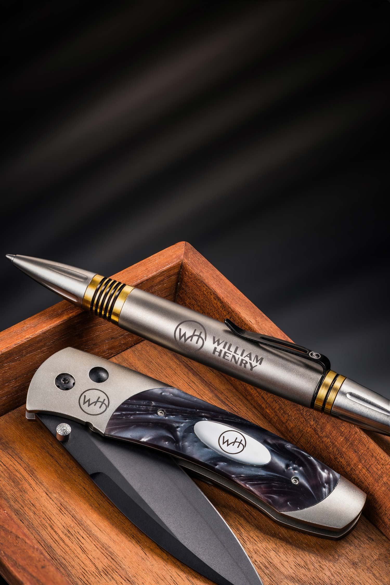 Pen and knife set with 'William Henry' branding on a wooden surface.