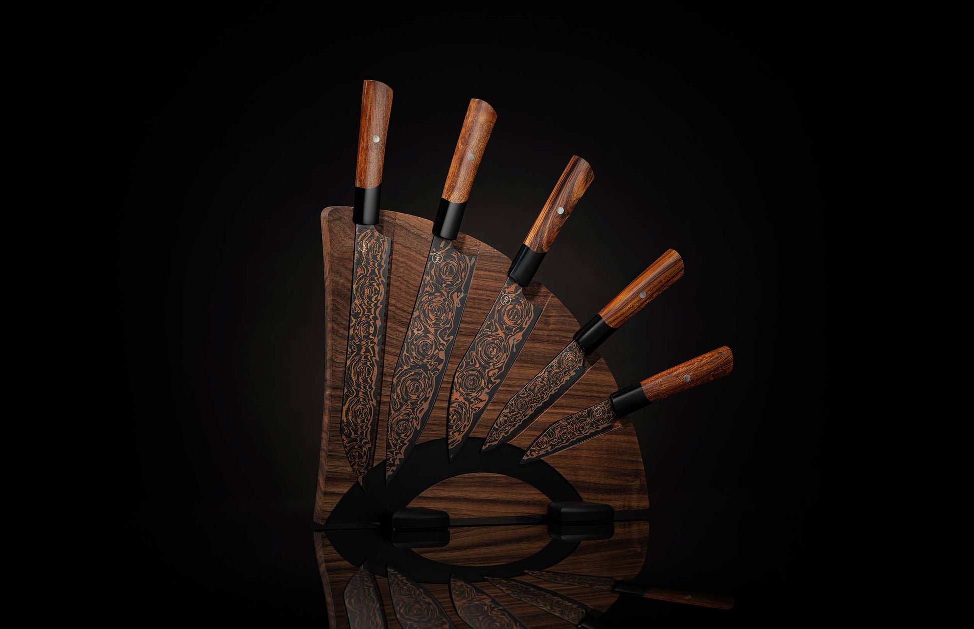 Set of chef knives with black blades and copper rose pattern, brown wooden handles, fanned on a dark wooden block with a reflection.