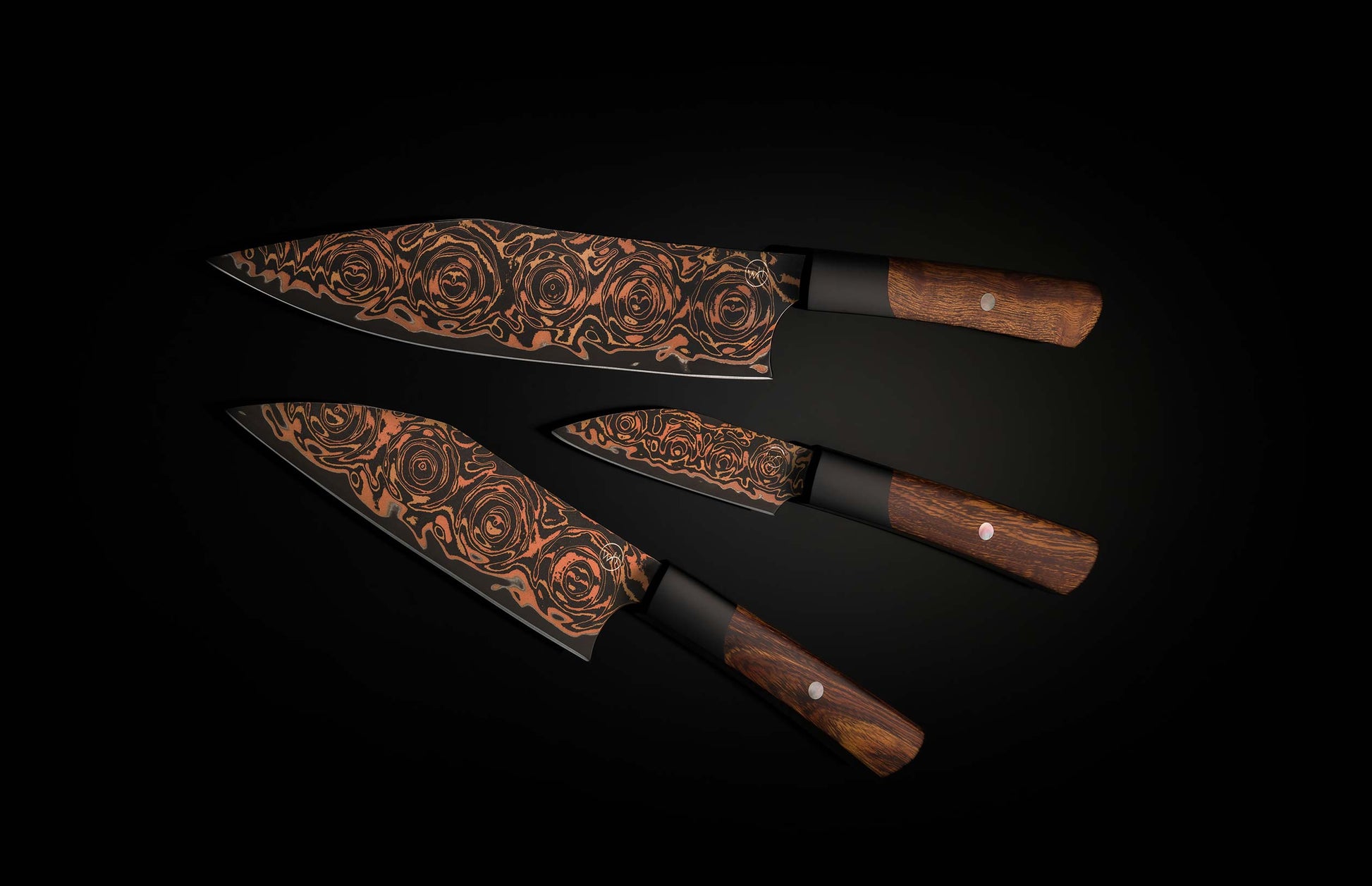 Three black and copper chef knives with swirling rose patterns on blades, dark wood handles, and black bolsters.