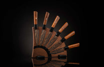 K22S-BLK-W| set of steak knives on a wooden blockSix steak knives with dark wooden handles, black blades with golden swirl patterns, in a fanned-out magnetic wooden block.