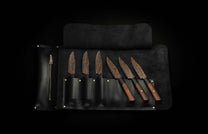 K22S-BLK-W| steak knives in leather caseSet of six steak knives with black and orange patterned blades and dark wood handles, displayed in an open black leather knife roll.