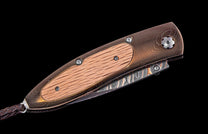 Folding knife with wooden handle and decorative blade on a black background