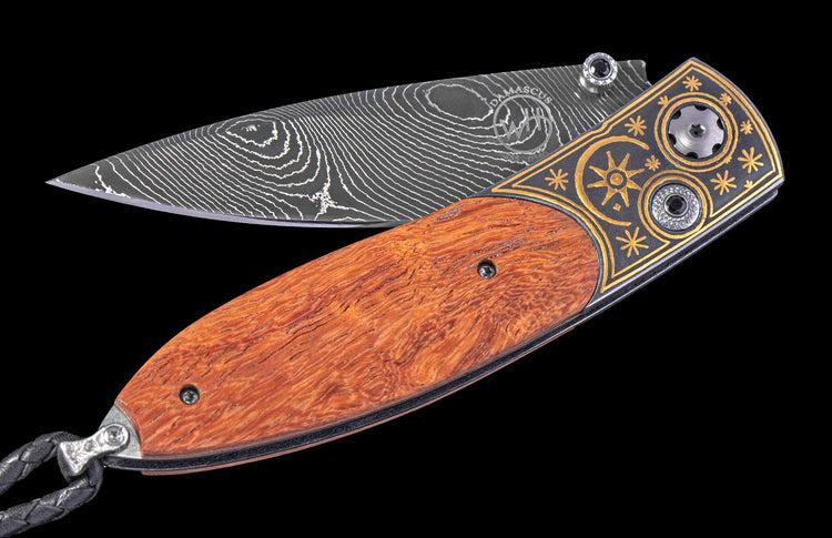 Decorative knife with wooden handle and damascus steel blade on a black background