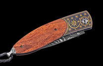 Decorative knife with wooden handle and damascus steel blade on a black background