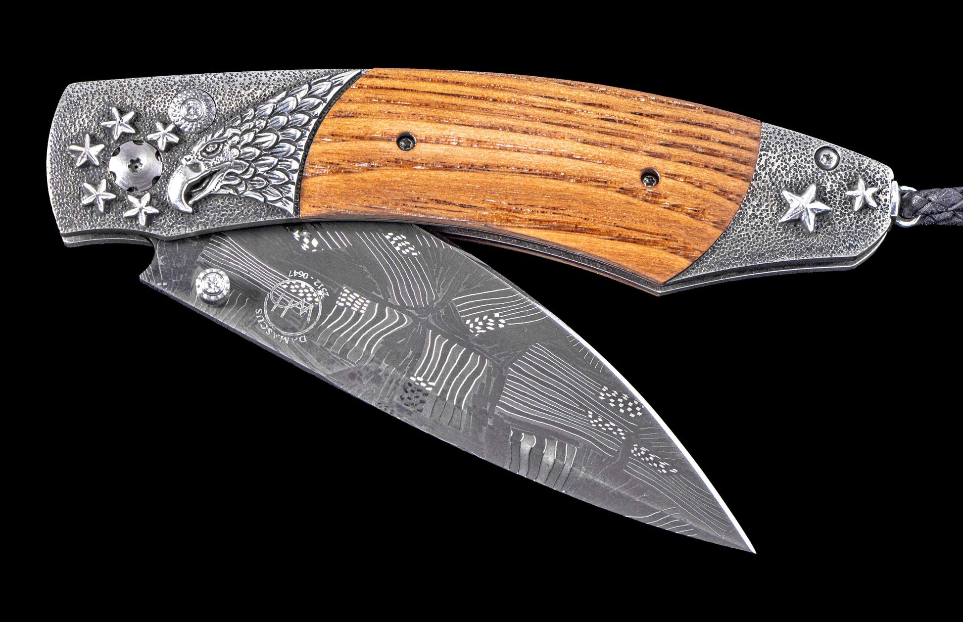 Decorative folding knife with wooden handle and damascus blade on a black background