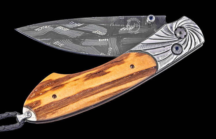Folding knife with wooden handle and decorative blade on a black background