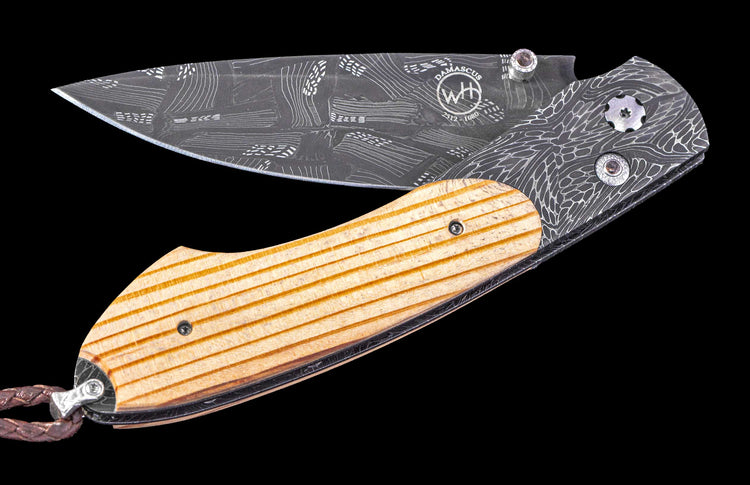 Folding knife with wooden handle and engraved blade on a black background
