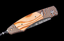 Knife with wooden handle and decorative blade on a black background