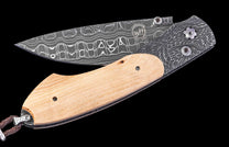 Folding knife with wooden handle and damascus steel blade on a black background