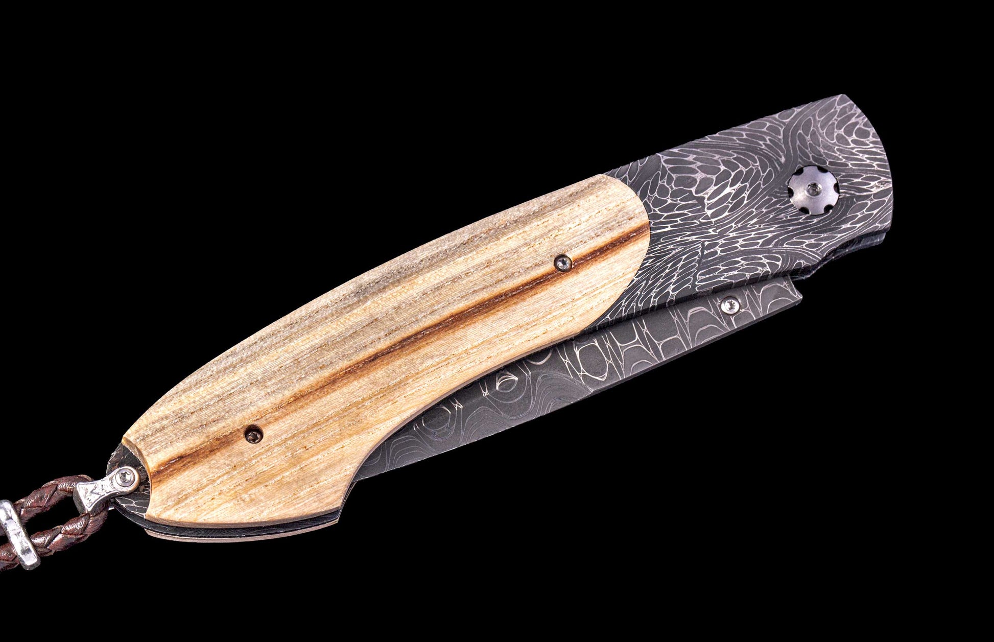 Folding knife with wooden handle and damascus steel blade on a black background