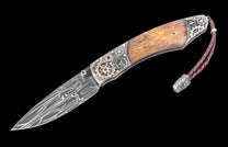 Decorative folding knife with wooden handle and metal embellishments on a black background