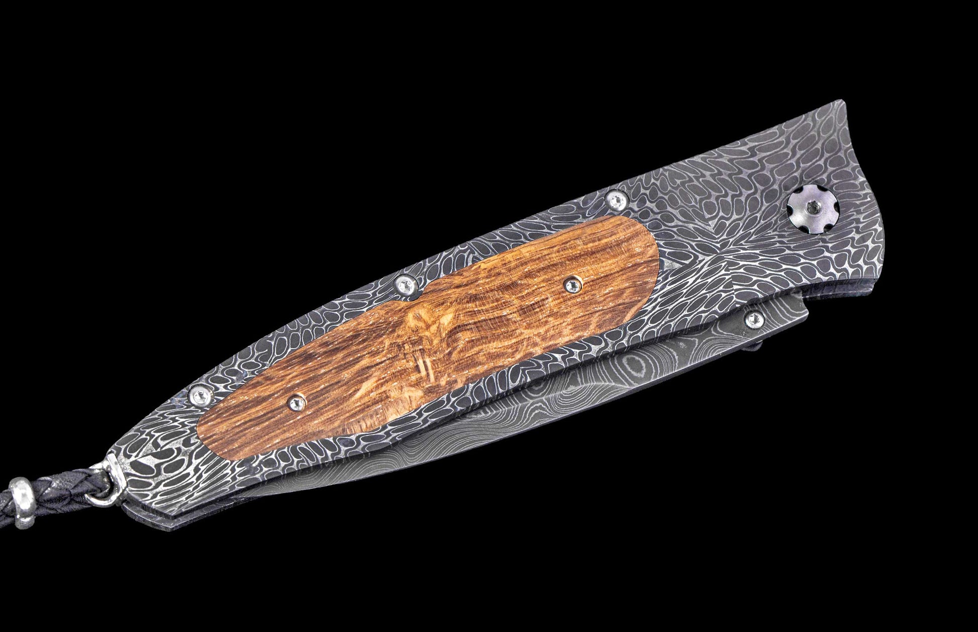 Handmade folding knife with wooden handle and damascus steel blade on a black background
