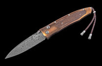 Folding knife with Damascus blade and wooden handle on a black background