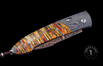 Auto knife with a layered orange, yellow, and blue handle, Damascus steel frame, wavy patterned blade, and copper-toned pocket clip.