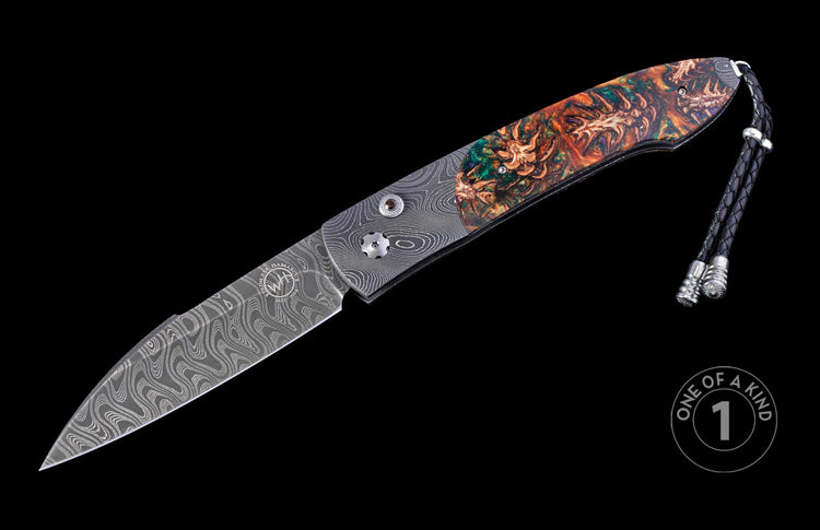 Autoknife with a wavy Damascus steel blade featuring an engraved emblem, a vibrant green and orange resin handle with organic inclusions, and a black braided leather lanyard.