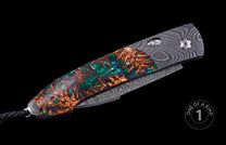 Automatic knife with iridescent resin and pine cone handle, Damascus blade, and black leather lanyard.